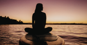 woman meditating at sunset